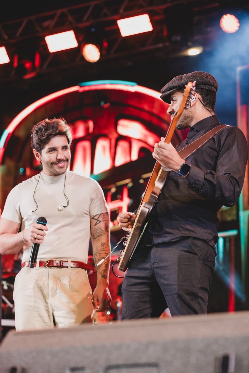 Euller tocando guitarra no palco com Hugo & Guilherme